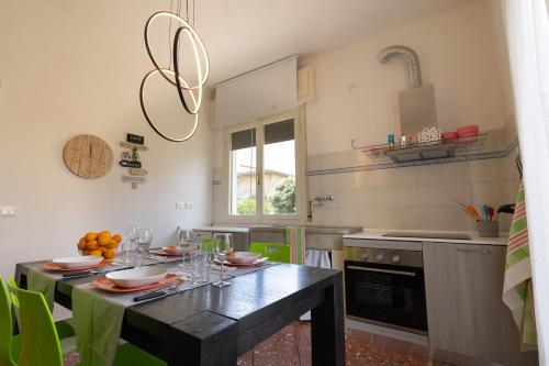 een keuken met een tafel met borden en glazen erop bij Casa indipendente, 250 m dalla spiaggia in Pisa