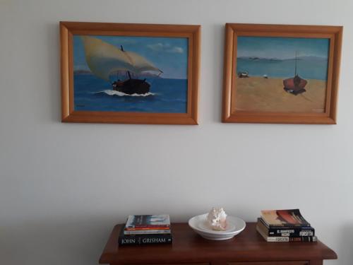 two framed paintings of a sail boat on the beach at A Pasos de la Playa in Papudo