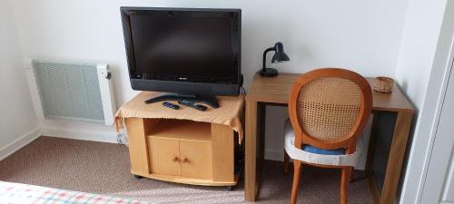 a desk with a television on top of a desk with a chair at A Pasos de la Playa in Papudo