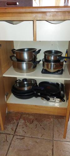 a shelf with pots and pans on a table at A Pasos de la Playa in Papudo