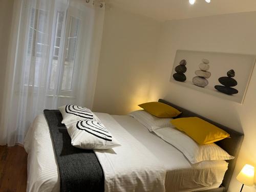 a bedroom with a bed with yellow pillows and a window at Apartman Passagio in Rovinj
