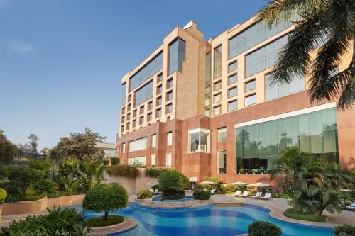 um edifício com piscina em frente a um edifício em Sheraton New Delhi Hotel em Nova Deli