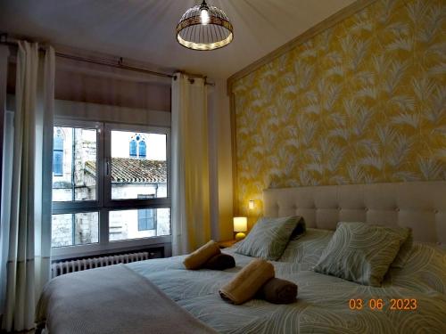 a bedroom with a large bed with a window at Apartamentos Cuéntame Burgos - VUT in Burgos