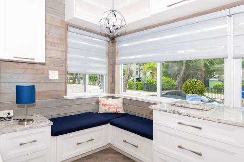 a kitchen with a blue bench in front of two windows at Tropic Isle Boutique Hotel in Hollywood