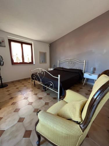 a bedroom with a bed and a couch and chairs at Piccola Mansarda in Parghelia