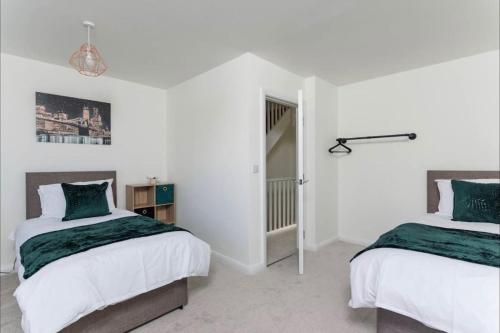 2 łóżka w pokoju z białymi ścianami w obiekcie Luxury 3-Bedroom, 2-Bathroom Home sleeps 7 people w Liverpoolu