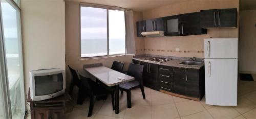 una pequeña cocina con mesa y TV. en Apartment in Atacames, en Atacames