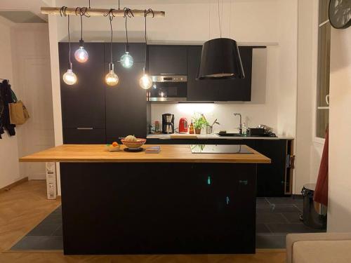 a kitchen with black cabinets and a wooden counter top at Petit Paradis in Nice