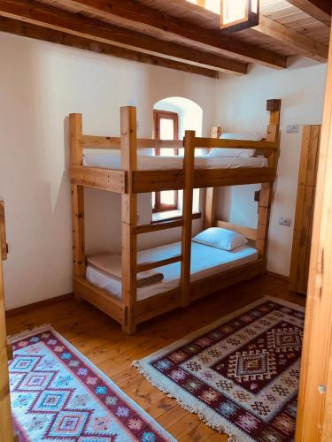 a room with two bunk beds and a rug at Guest House and Hostel VAL-MAR in Gjirokastër