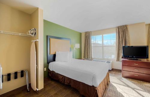 a hotel room with a bed and a flat screen tv at Extended Stay America Suites - Las Vegas - East Flamingo in Las Vegas