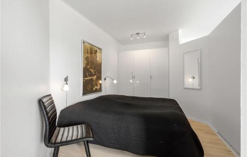 a dining room with a black table and a chair at Fanø Bad, Lejl 107 in Fanø