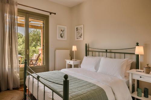 a bedroom with a green bed and a balcony at Oleanna Villas - Villa Elena in Svoronata