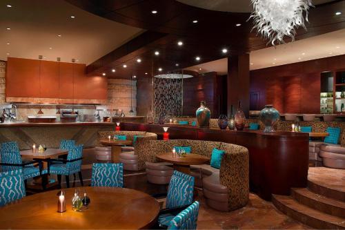 a restaurant with tables and chairs and a bar at The Nile Ritz-Carlton, Cairo in Cairo