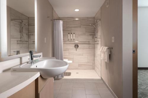 ein Badezimmer mit einem weißen Waschbecken und einer Dusche in der Unterkunft SpringHill Suites by Marriott Dallas Rockwall in Rockwall
