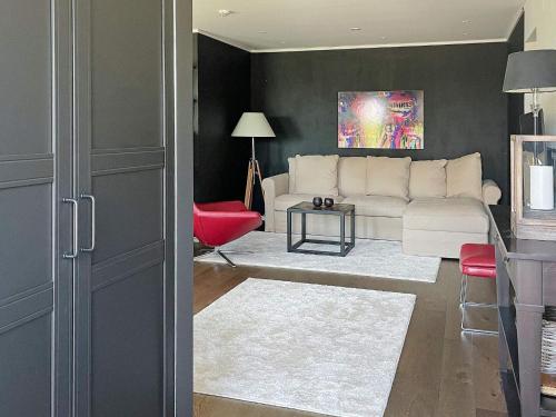 a living room with a white couch and a red chair at Holiday home Onsala IV in Onsala