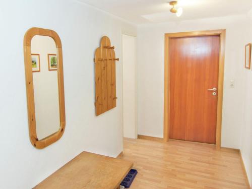 ルーポルディングにあるPeaceful Holiday Home in Ruhpolding with Saunaの鏡と木製のドアが備わる部屋