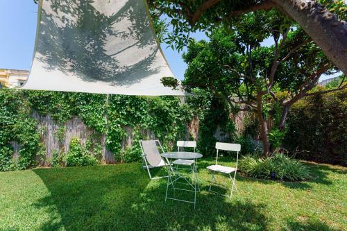 two chairs and a table in a yard at Poseidonia Rooms in Procida