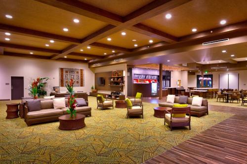 a lobby with couches and chairs and a bar at Courtyard by Marriott Oahu North Shore in Laie