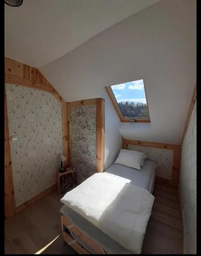 Dormitorio pequeño con cama en el ático en Aprtamenty Pod Dobrym Aniołem - domek, en Kudowa-Zdrój