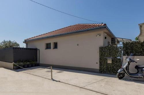 a scooter parked in front of a white garage at Villa KaTess with heated pool in Split
