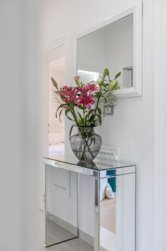a vase with flowers on a glass table in front of a mirror at Villa KaTess with heated pool in Split