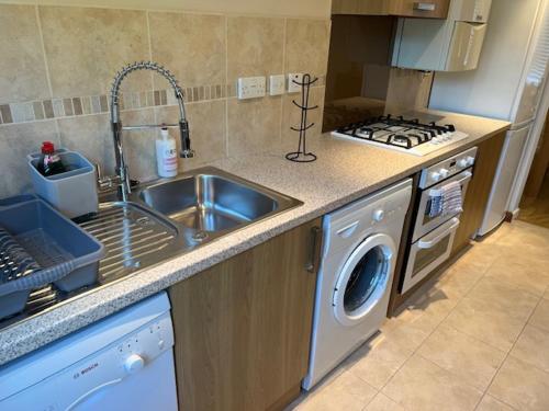 a kitchen with a sink and a washing machine at Tree View Apartment in Chesterton