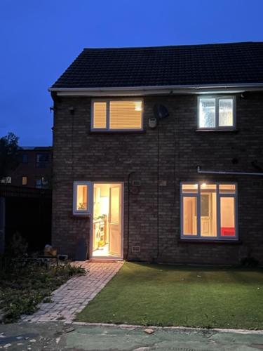 a brick house with a door and a grass yard at Tree View Apartment in Chesterton