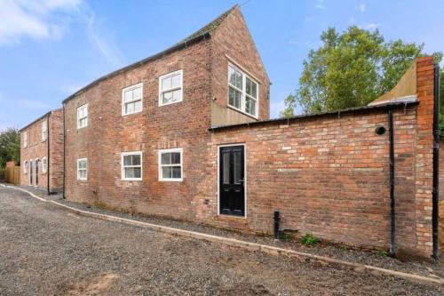 a brick building with a door on the side of it at Cosy newly renovated 3 bedroom house - Town centre Horncastle in Lincolnshire