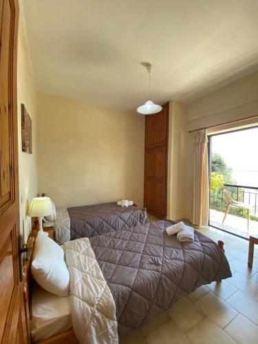 a bedroom with two beds and a large window at Vasiliki see view apartments in Barbati