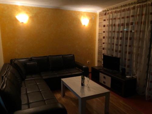 ein Wohnzimmer mit einem Ledersofa und einem Couchtisch in der Unterkunft Apartments Veronika in Ohrid