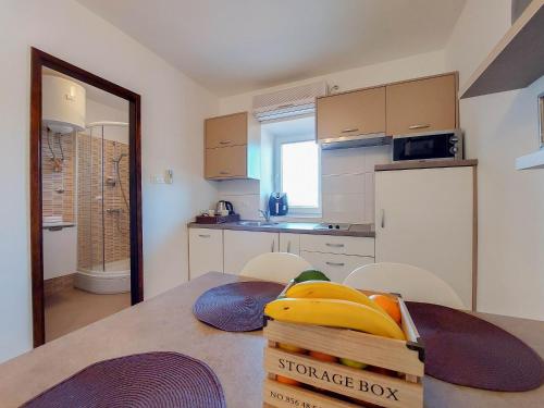 a kitchen with a table with a box of bananas at Apartment Marino in Čižići