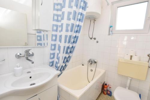 Apartment Vlasta في بريموستين: حمام مع حوض وحوض استحمام ومرحاض