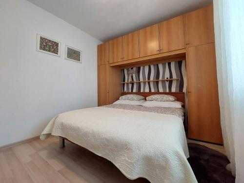 a bedroom with a bed with a wooden headboard at Apartment Marino in Čižići