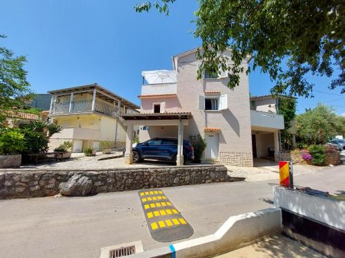 a house with a blue car parked in a driveway at Apartment Marino in Čižići