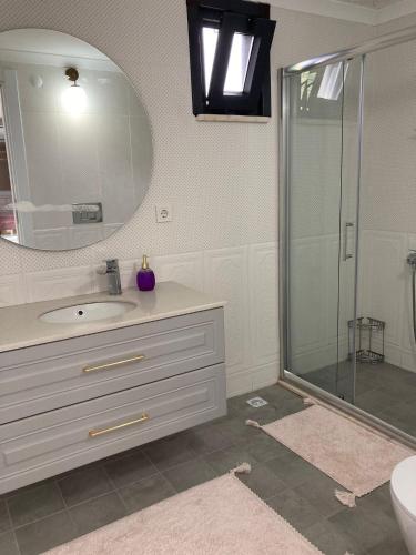 y baño con lavabo y ducha con espejo. en Doğa içinde ferah huzurlu müstakil ev en Of