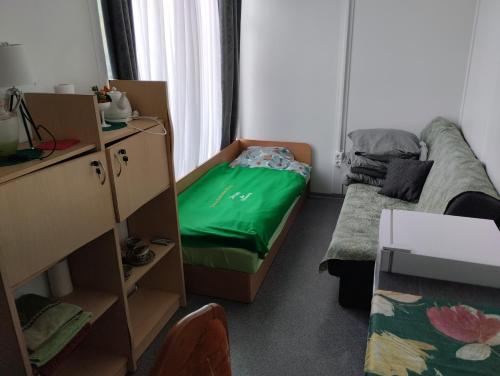 ein kleines Zimmer mit einem Bett und einer grünen Matratze in der Unterkunft Šaltupio kaimo turizmas 
