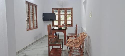 comedor con mesa, sillas y TV en PADAVAYAL GREENS, en Attappādi