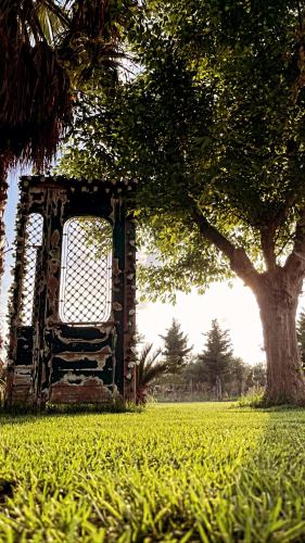 a building sitting in a field with a tree at Mama’s Sunshine Garden Villa in Áyios Ilías