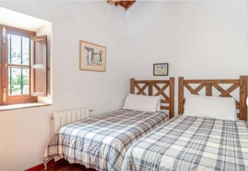 ein Schlafzimmer mit zwei Betten und einem Fenster in der Unterkunft Molino del Caracol in Benaoján