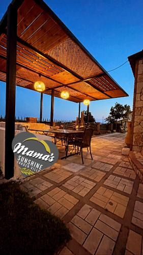 a wooden pergola with a table and chairs on a patio at Mama’s Sunshine Garden Villa in Áyios Ilías