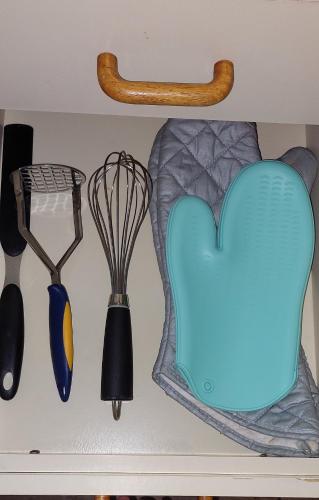 a shelf with some kitchen utensils and a heart magnet at A Pasos de la Playa in Papudo