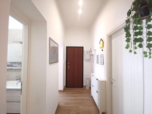 - un couloir avec une porte marron dans une chambre blanche dans l'établissement Casa di Serena, à Mestre