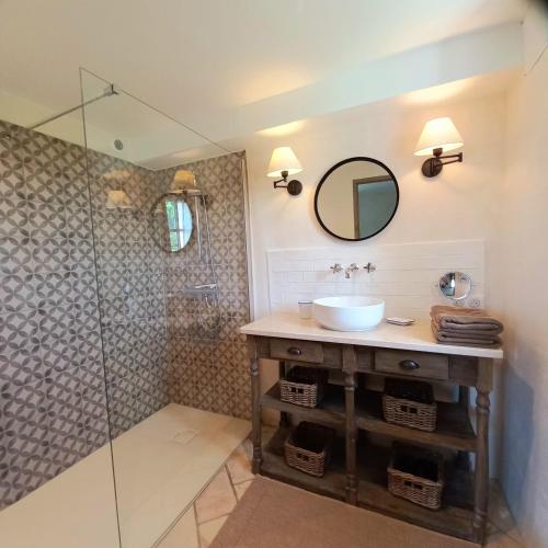 une salle de bain avec un lavabo et une douche dans l'établissement Le Cottage du Chat Blanc, à Saint-Didier