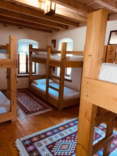 a room with three bunk beds and a rug at Guest House and Hostel VAL-MAR in Gjirokastër