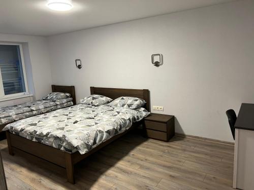 1 dormitorio con 2 camas individuales y ventana en Апартаменти, en Beregovo