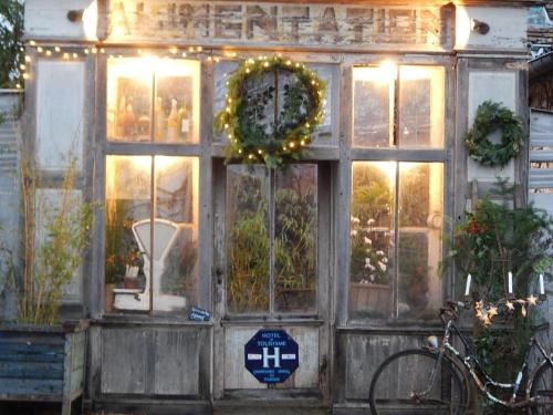 a store front with a wreath and a bicycle in front at La cabane de Mimi la Sardine in Saint-Gervais en-Belin