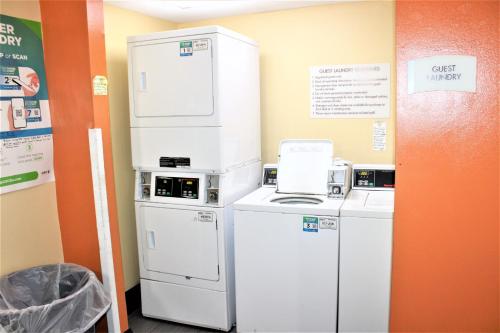 a kitchen with two refrigerators and a microwave at Trident Inn & Suites New Orleans in New Orleans