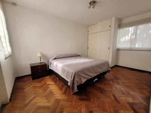 1 dormitorio con 1 cama y suelo de madera en Dpto. 25 de Mayo y Las Heras en Mendoza