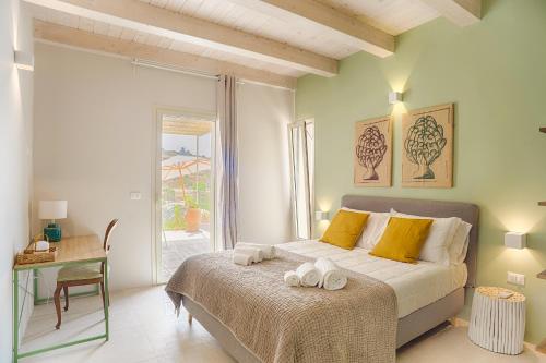 een slaapkamer met een bed met handdoeken erop bij Azalo Country House in Noto