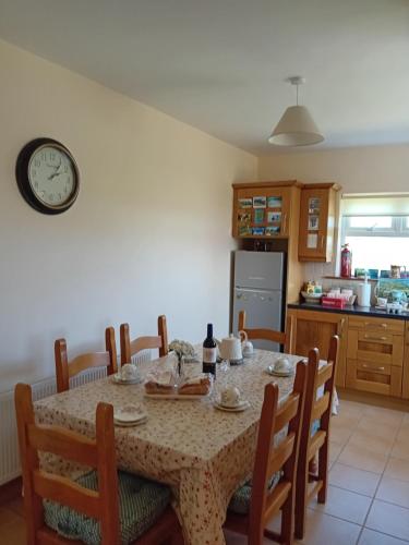 a kitchen with a table with chairs and a clock on the wall at Causeway Country Lodge in Causeway